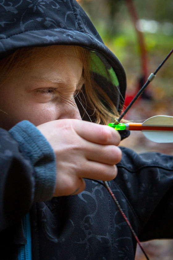 A first time archer draws her bow, focuses on the target, and lets loose. | © Matt Giraud Photography